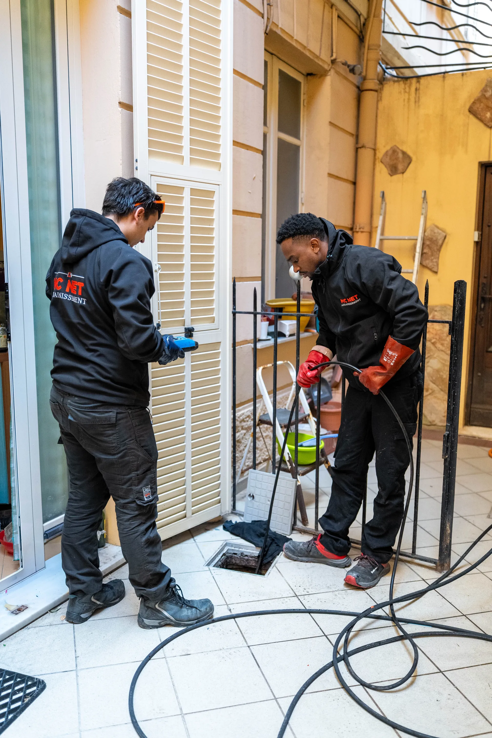Techniciens MC NET Assainissement en intervention de débouchage haute pression