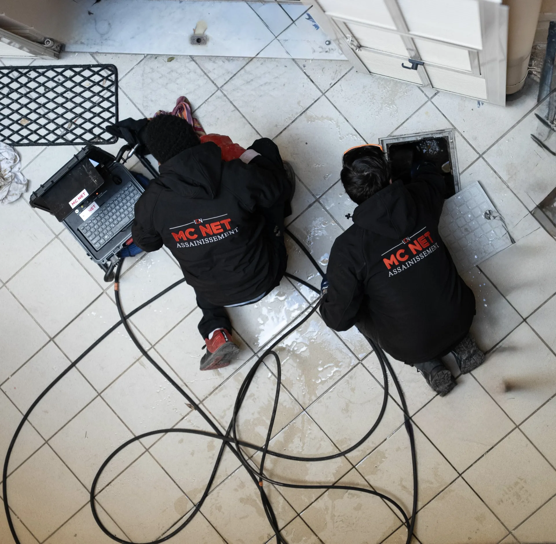 Techniciens MC NET Assainissement réalisant une inspection caméra de canalisation