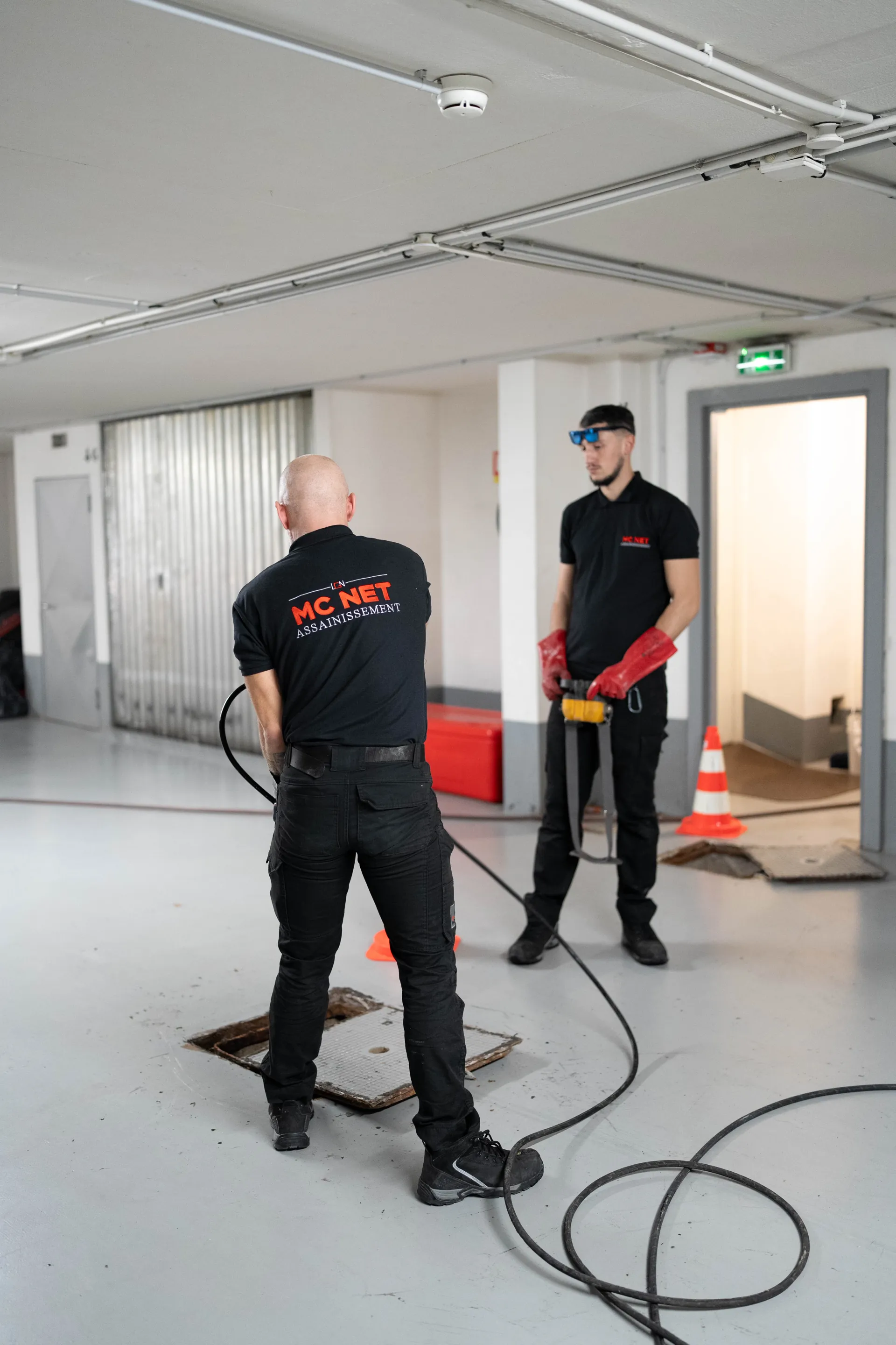 Techniciens MC NET Assainissement préparant un curage de canalisation