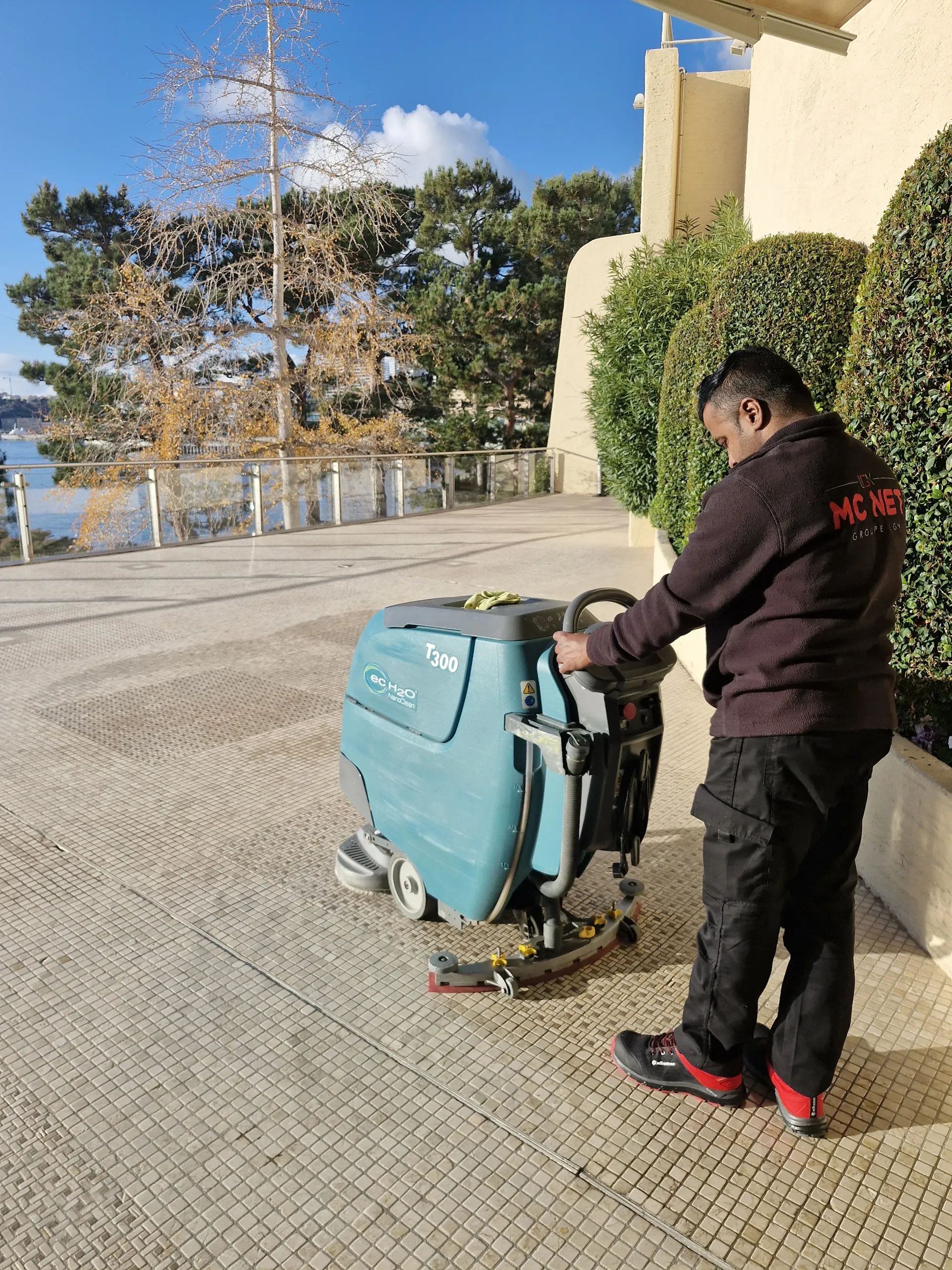 Agent MC NET Nettoyage avec autolaveuse sur une terrasse en bord de mer